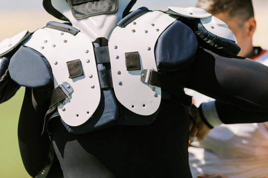 Athletes before the game putting on protection and uniform
Ameri
