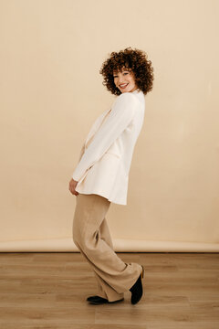 Happy stylish woman standing in studio