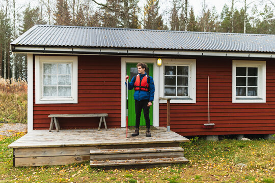 Man standing by cabin in wilderness