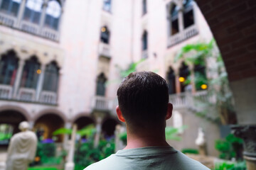 Man from behind admires beautiful green yard, travel destination concept