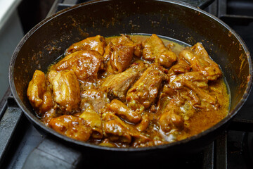 Chicken pieces in a sauce with paprika and turmeric in gravy are stewed in a frying pan