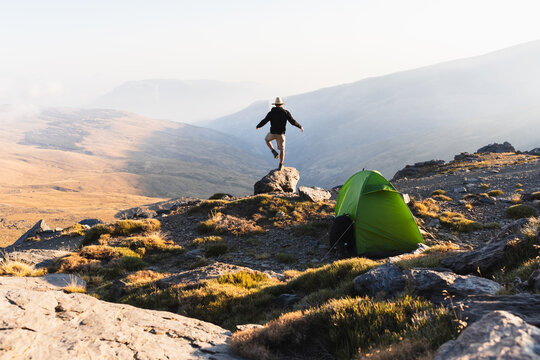 Traveler with tent in mountainous terrain