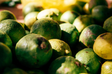 Ripe green limes in close-up, on a counter or shelf, in a store or hypermarket - obrazy, fototapety, plakaty