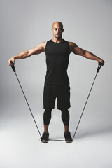 Man, fitness and stretch band in studio with workout for health with athlete for training with wellness. Body care, gym and confidence with commitment for motivation with exercise on gray background