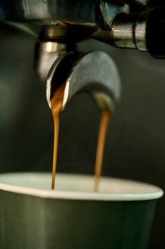 coffee is poured into a disposable cup