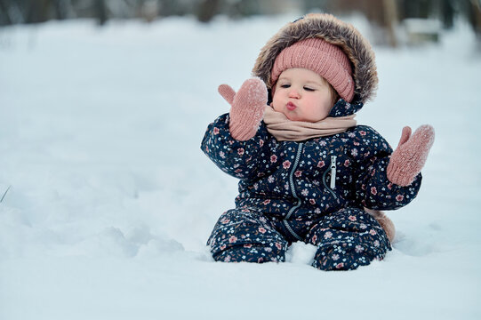 a small child is blowing snow