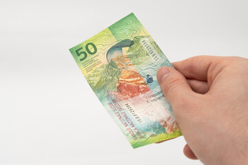 Man holding 50 CHF Swiss franc banknote paper currency isolated on white background