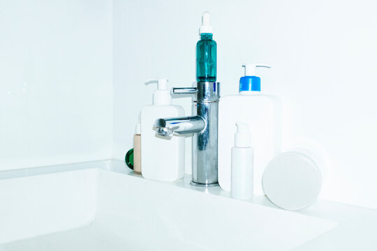 View of bathroom sink and water tap & skincare lotions, serums 