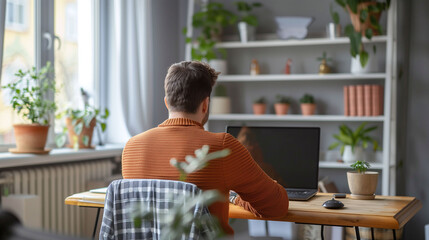 Focused Individual Working on a Laptop in a Comfortable Home Office