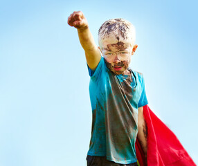 Dirt, mud and portrait of child with superhero costume, fist and confidence playing outside...