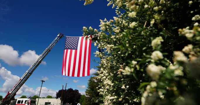 American flag hanging on fire trucks for a military memorial
