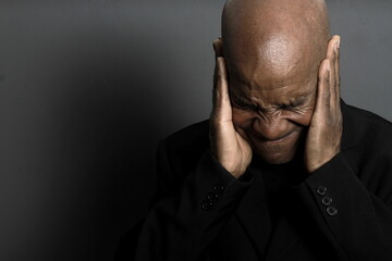 deaf man suffering from deafness and hearing loss on grey black background with people stock image stock photo	