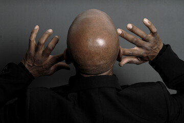 deaf man suffering from deafness and hearing loss on grey black background with people stock image...