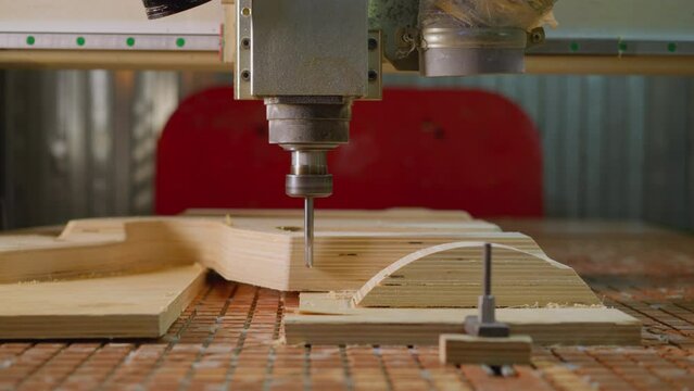 Close-up of CNC router machine at work on plywood creating a complex geometric pattern with precision