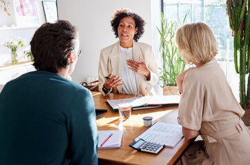 Financial advisor meeting with couple at table in modern home