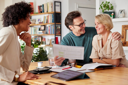 Smiling financial advisor discussing insurance policy with couple
