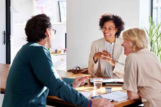 Happy couple having finance discussion with consultant at home