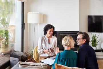 Couple discussing home finance with female advisor