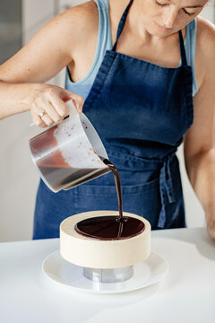 The pastry chef effectively pours mirror glaze on the cake