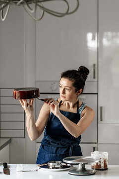 The girl is concentrating on making a mousse chocolate cake