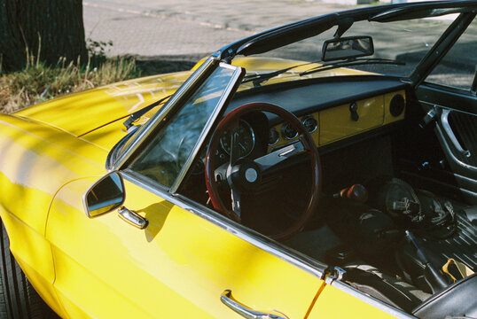 Detail of an oldtimer cabriolet car in bright yellow
