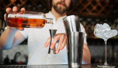 Fototapeta na wymiar Bartender Pouring Whiskey Into Jigger at Trendy Bar