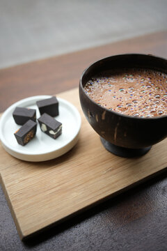 Hot cocoa in coconut shell with artisanal chocolates, ceremony