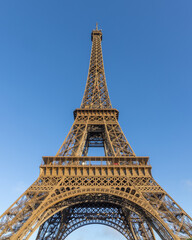 Fototapeta na wymiar Paris, the Eiffel Tower from below against a blue sky. tall perspective photograph