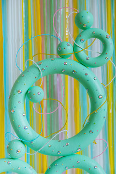 Green colored torus with with sparkles, beads on a coloured background