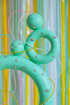 Green colored torus with with sparkles, beads on a coloured background