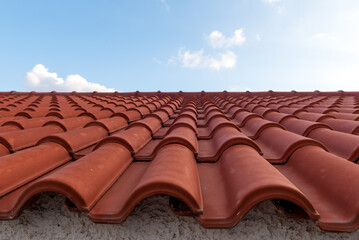 Red tile roof under blue sky. One part is a roof and the other is a pure blue sky.