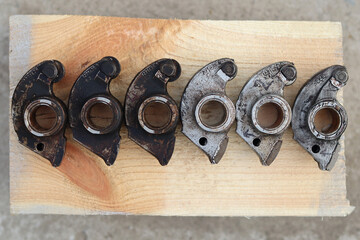 Original factory rocker arms for the intake valves, clean and dirty covered in a layer of black soot.