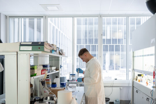 Male Researcher Working In Bright Lab Room