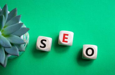 SEO - Search Engine Optimization symbol. Wooden blocks with words SEO. Beautiful green background...