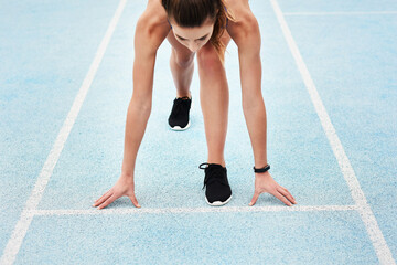 Woman, athlete and start on track field for running, training and fitness in summer. Professional...