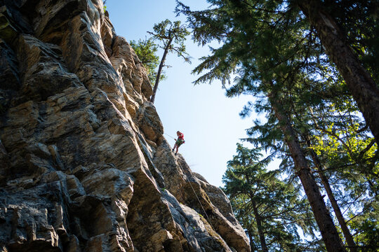 boy hanging on a rope on a cliff