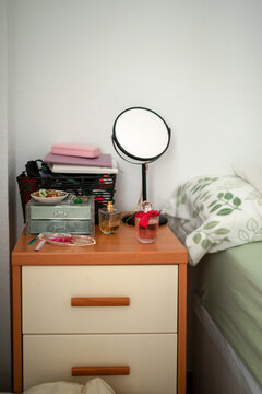 nightstand next to the bed in a bedroom that is disorganized