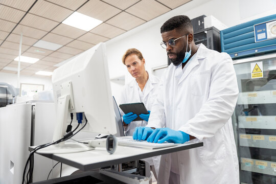 Team of Research Scientists Working On Computer