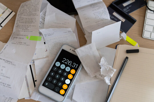 Mobile phone with calculator app. Utility bills, tax forms, invoices