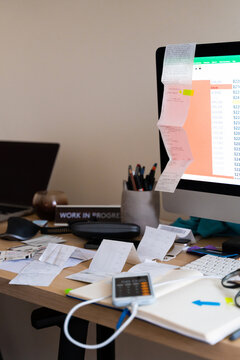 Busy, messy workplace with receipts, papers, and tax forms 