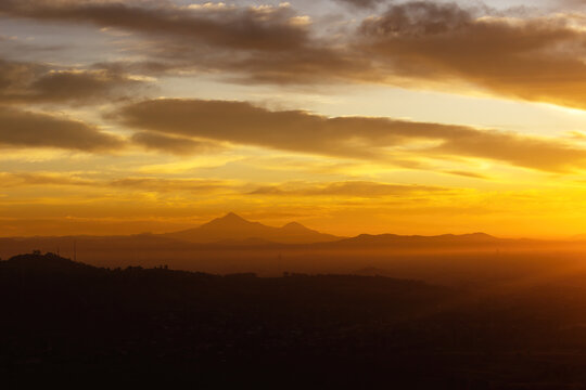 Pico de Orizaba volcano and Sierra Negra on the city skyline at dawn.