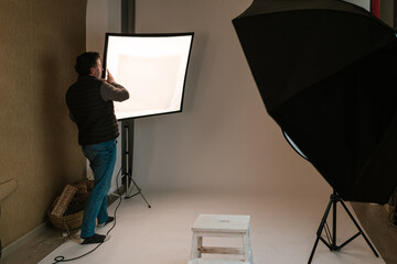 Man photographer adjusting lighting equipment