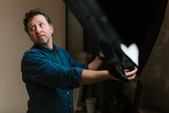 Adult man adjusting equipment in photo studio