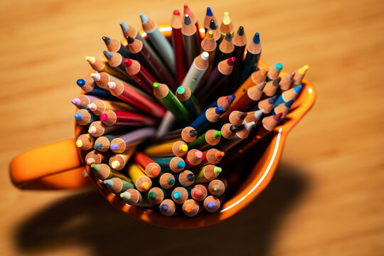 Assorted Colored Pencils in Orange Cup. Creativity concept