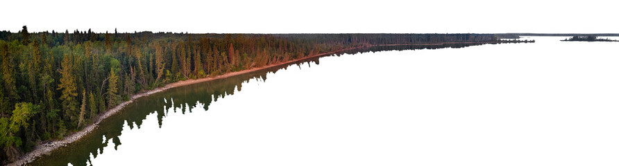 Aerial view of a lake with an evergreen tree covered shore. The sky and the water are transparent.
