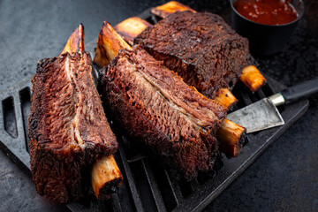 Traditional barbecue burnt chuck beef ribs marinated with spicy rub and served as close-up on a rustic cast iron grillage