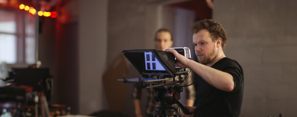 Director of photography with a camera in his hands on the set. Professional videographer at work on...