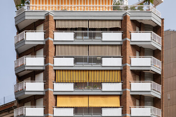 Apartment building with yellow stripe canopy and balconies