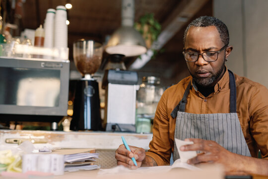 Cafe owner reviewing transactions 