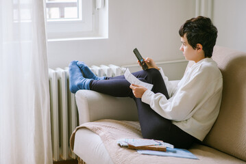Young woman pays heating bill with smartphone